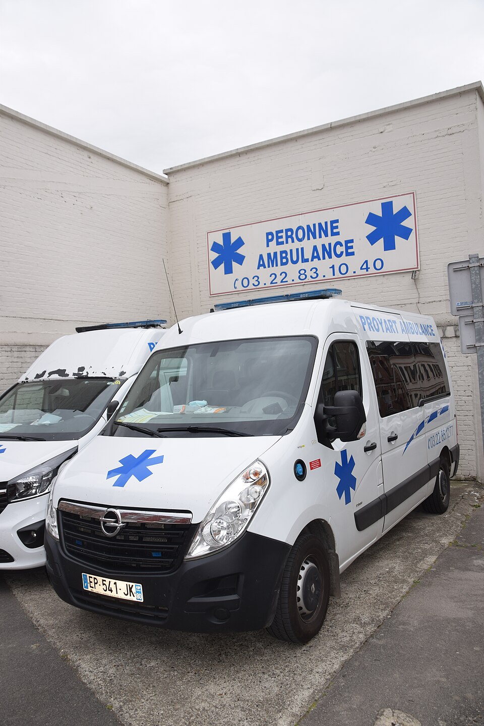 Deux ambulances privées stationnées devant une entreprise de transport sanitaire en France