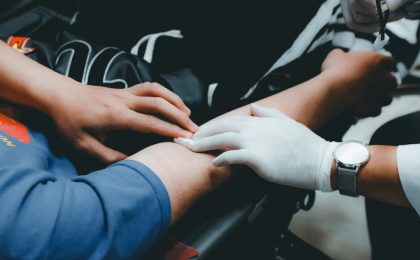 Professionnel de santé examinant la main d’un patient lors de l’évaluation de la perfusion périphérique