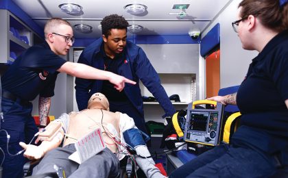 Deux professionnels en formation réalisent une simulation de prise en charge sur mannequin dans une ambulance